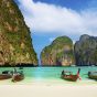 Thailand beach and boats towering rocks